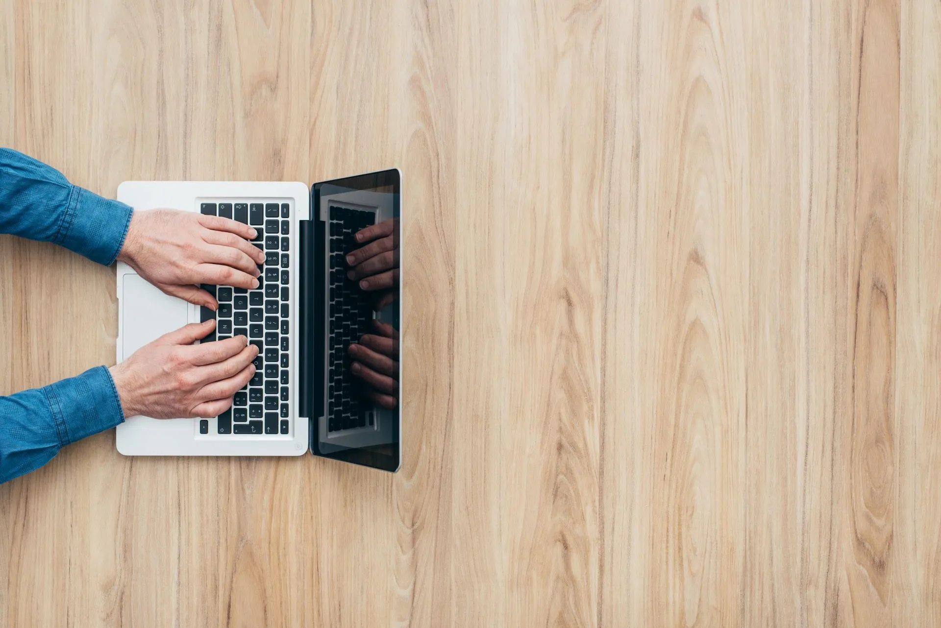 Bovenaanzicht van iemand die werkt achter zijn laptop