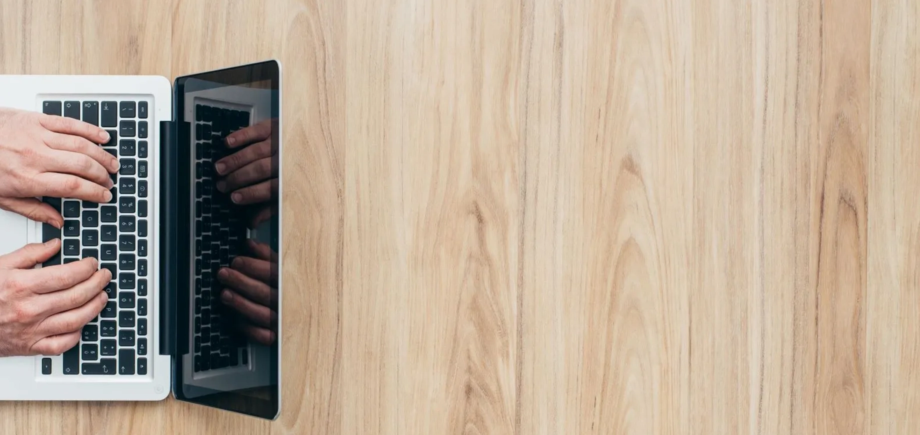 Bovenaanzicht van iemand die werkt achter zijn laptop