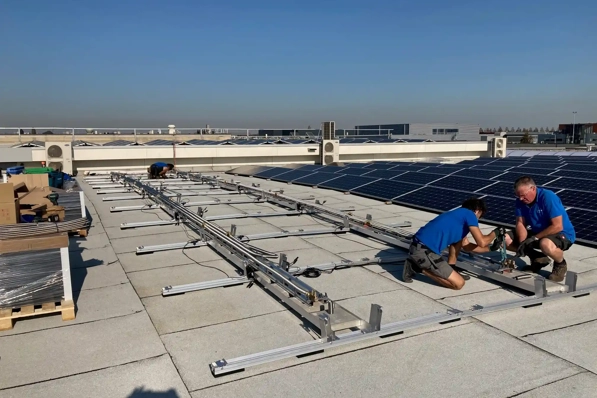 Installateurs zijn bezig met PVT panelen te installeren op dak