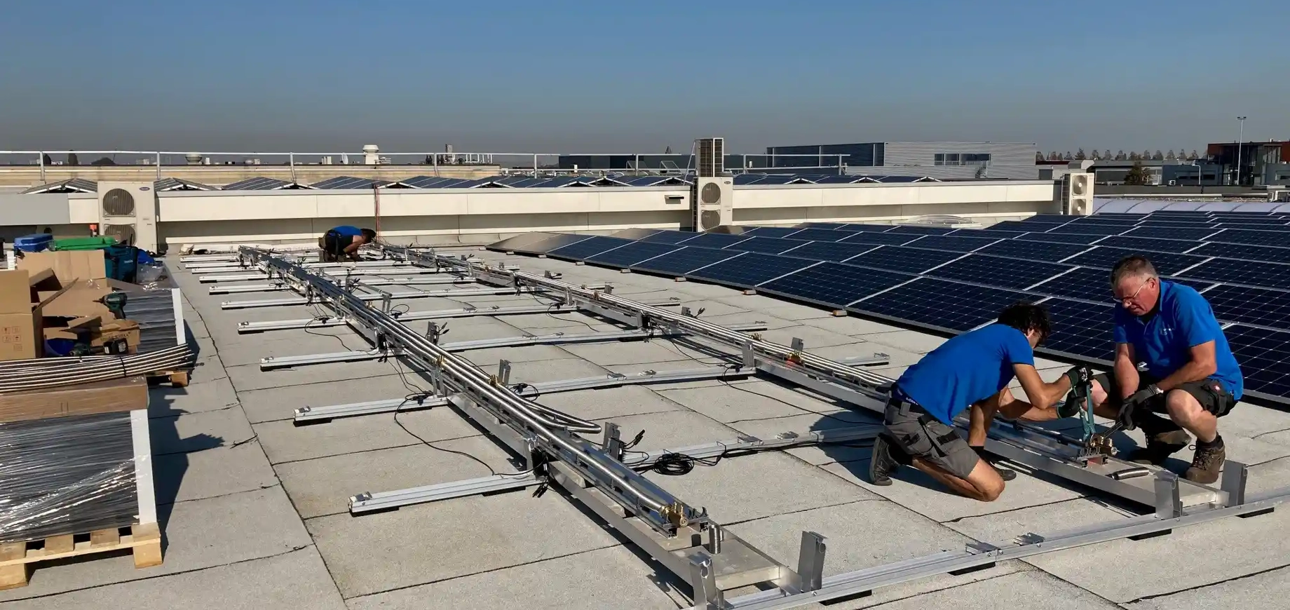 Installateurs zijn bezig met PVT panelen te installeren op dak