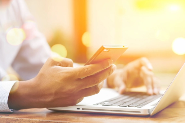 Mobiel en laptop in handen