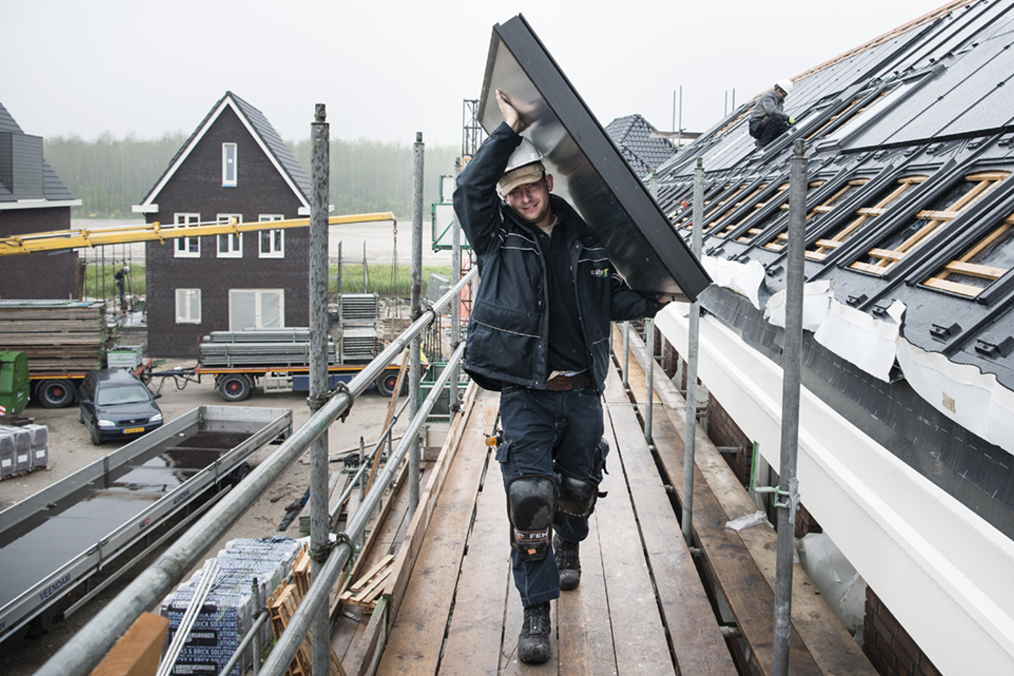 Installateur die zonnecollector op het dak tilt