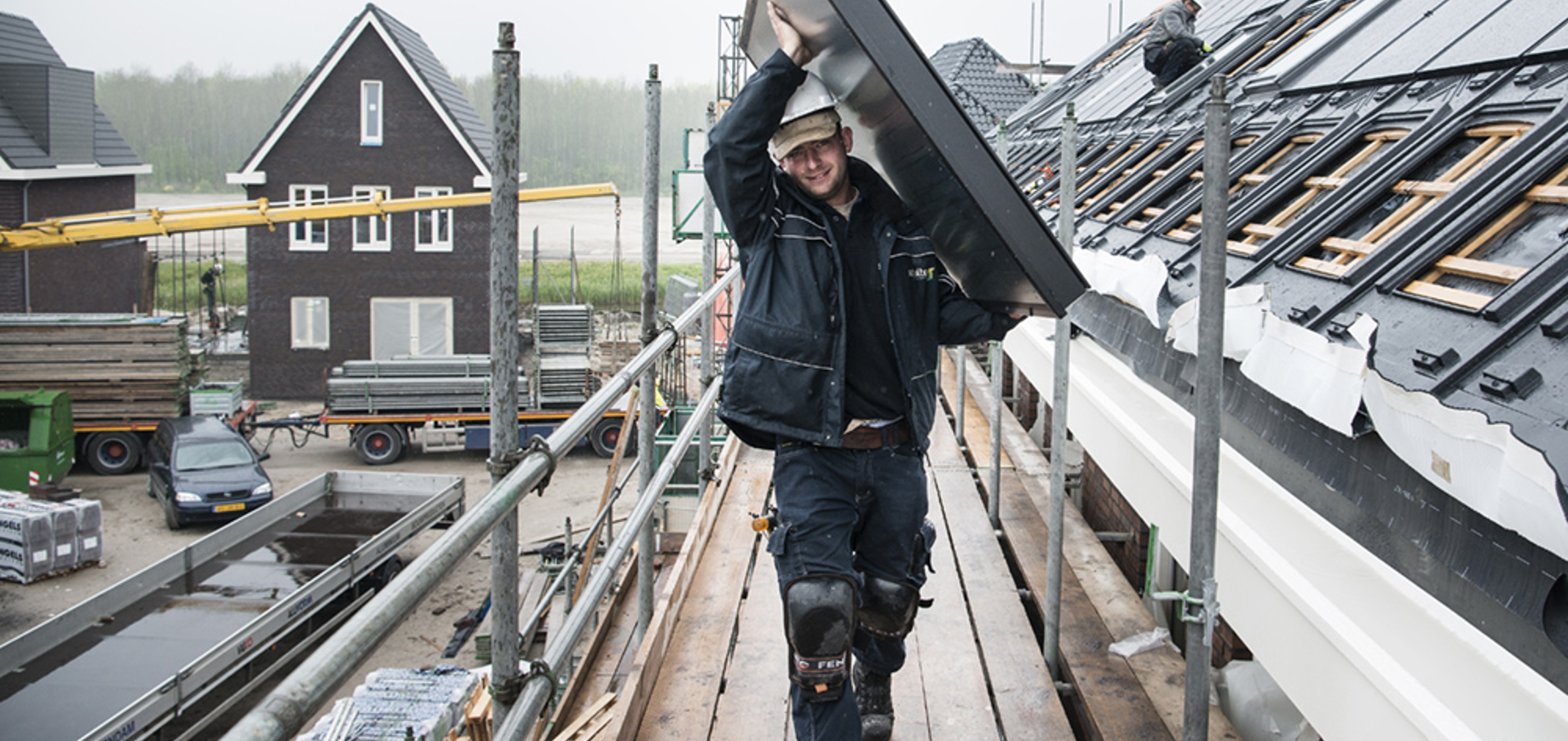 Installateur die zonnecollector op het dak tilt
