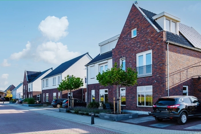 Straatbeeld met huizen en groene bomen in een rustige Nederlandse buurt
