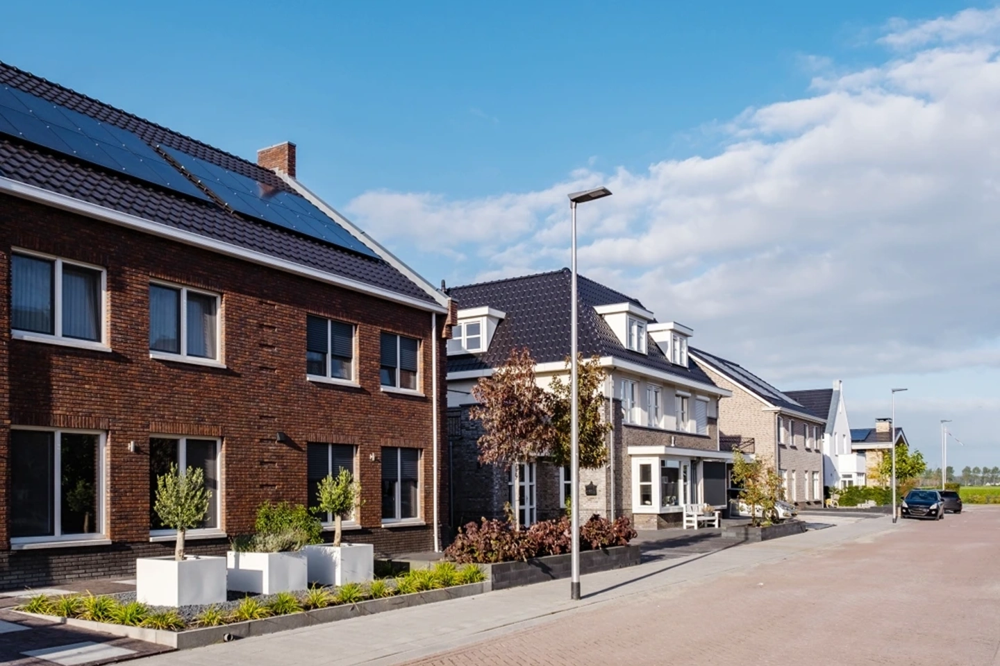 Straat met moderne woningen voorzien van zonnepanelen in een woonwijk