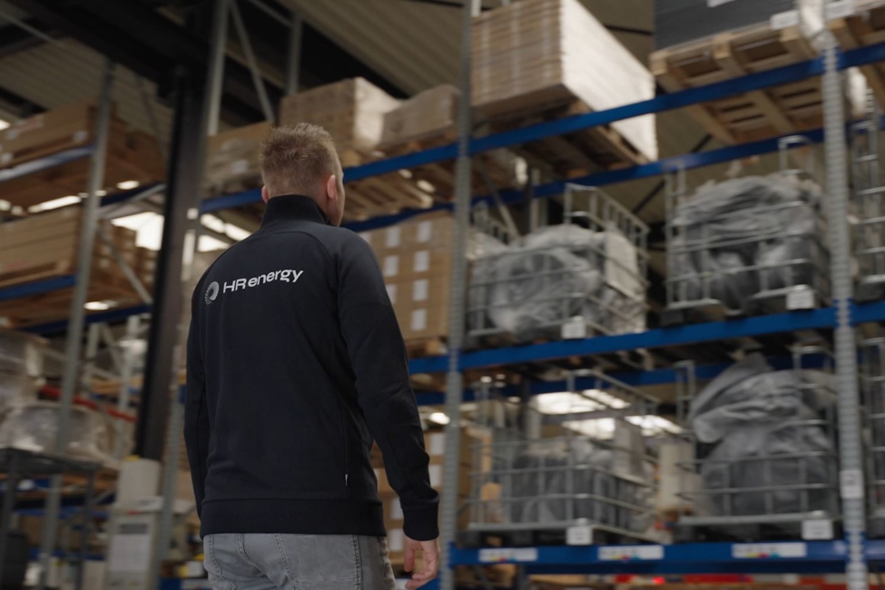 Medewerker HR energy loopt in magazijn met warmtepompen