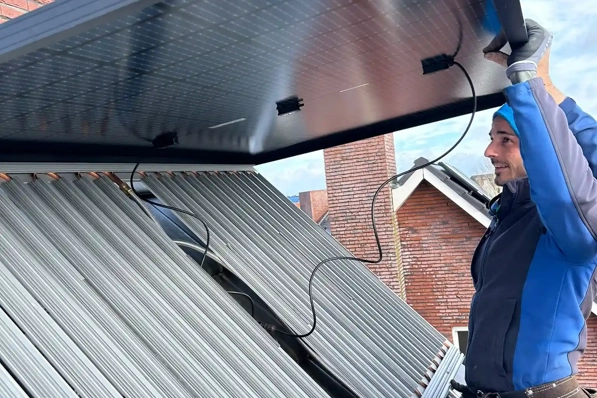 Installateur monteert PVT-paneel op het dak van een woning