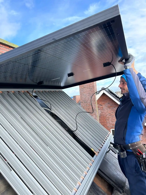 Installateur monteert PVT-paneel op het dak van een woning