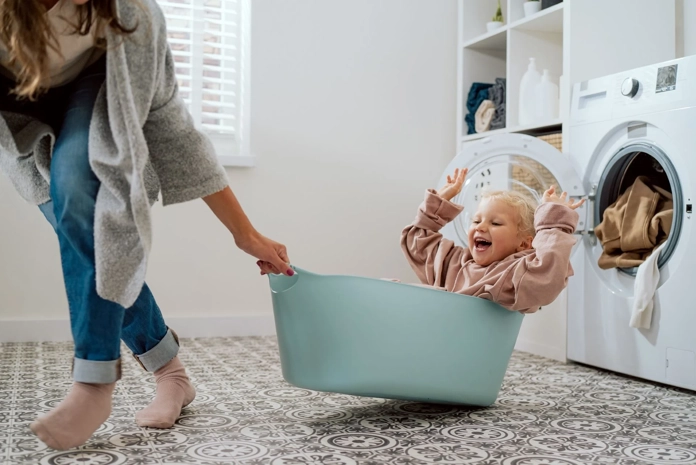 Kind in wasmand die omhoog wordt getild door vrouw
