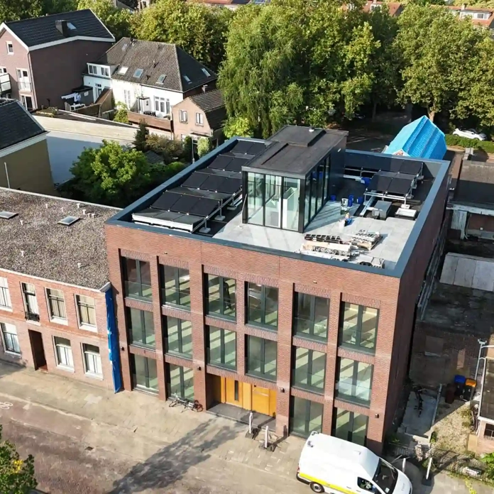 Zijaanzicht van een gebouw met PVT-panelen van HR energy op het dak