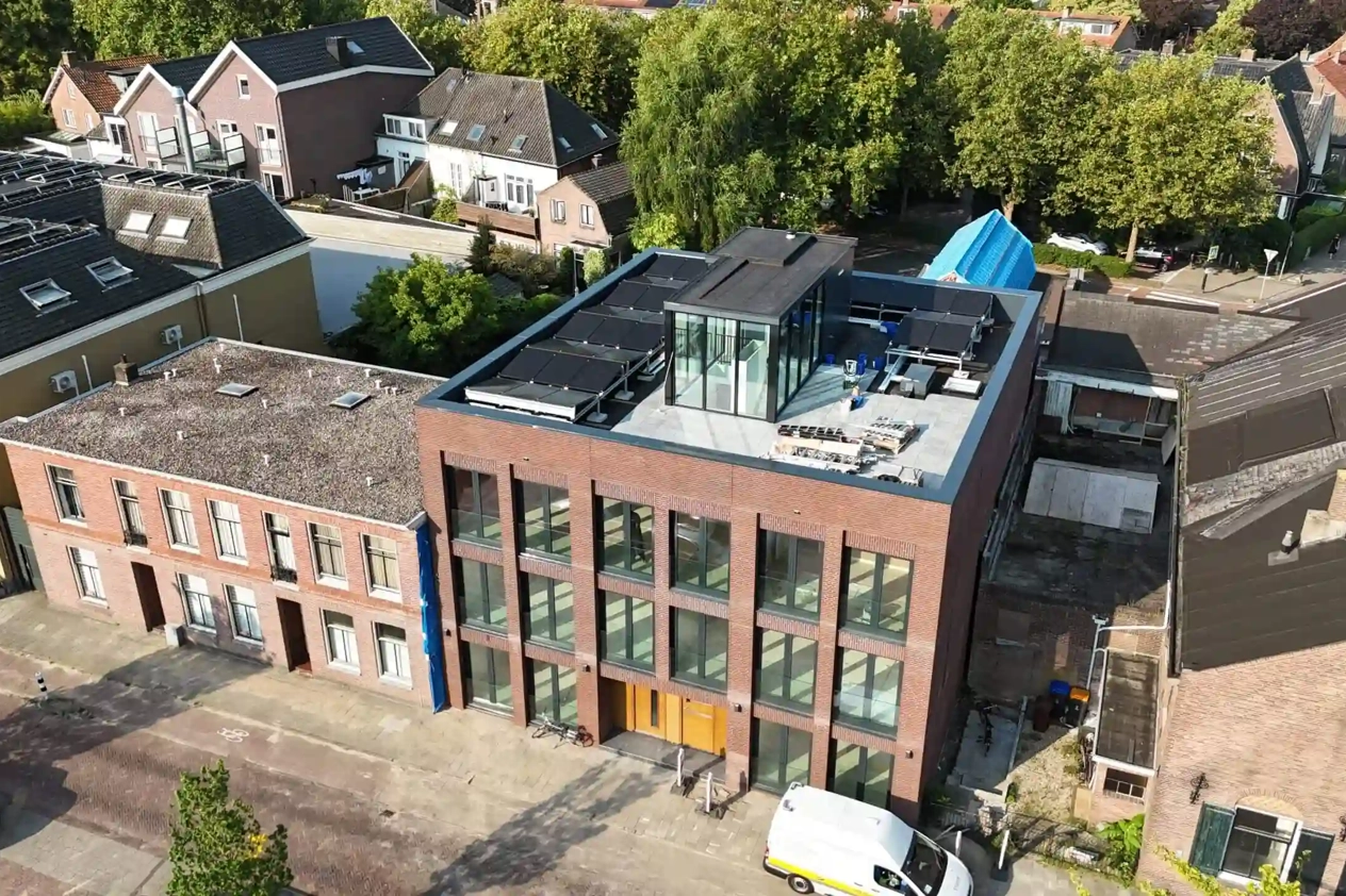 Zijaanzicht van een gebouw met PVT-panelen van HR energy op het dak