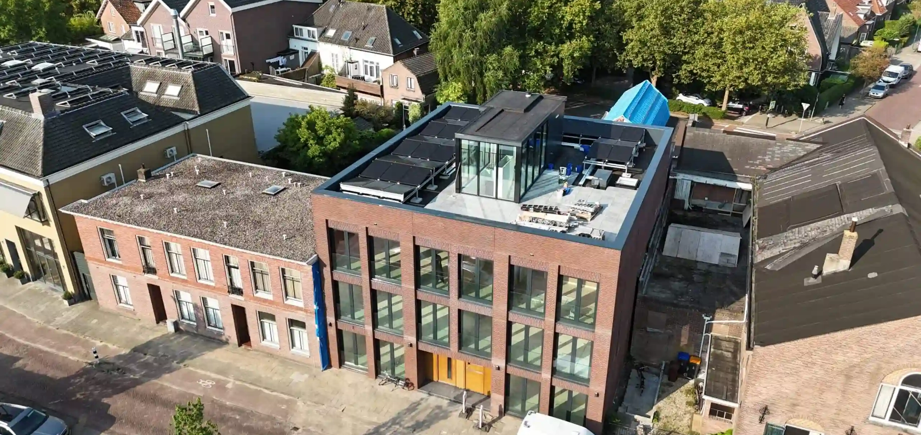 Zijaanzicht van een gebouw met PVT-panelen van HR energy op het dak