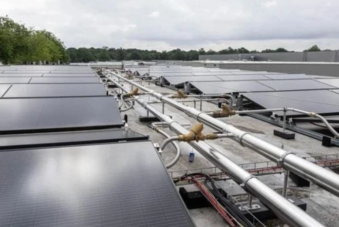 Monteurs plaatsen PVT-panelen op dak tijdens renovatie in Tilburg