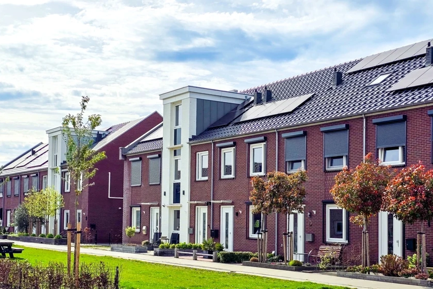 Een grasveld voor een rij woningen in Nederland