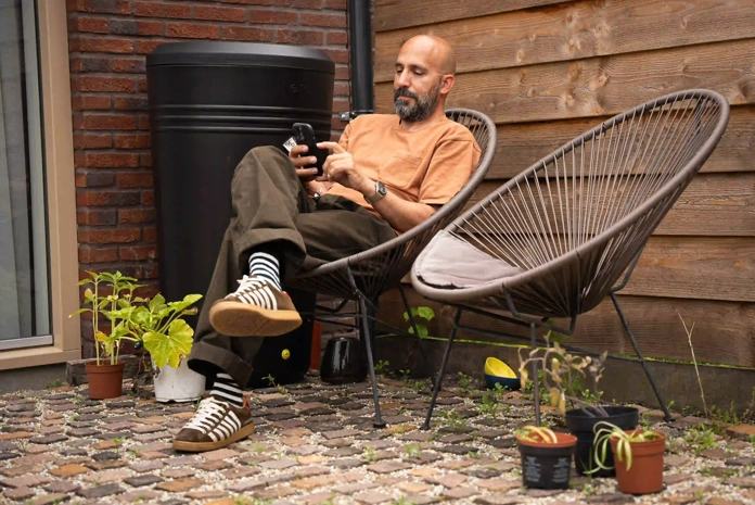 Man in tuin bekijkt HR energy LinQ app op zijn telefoon in De Meern