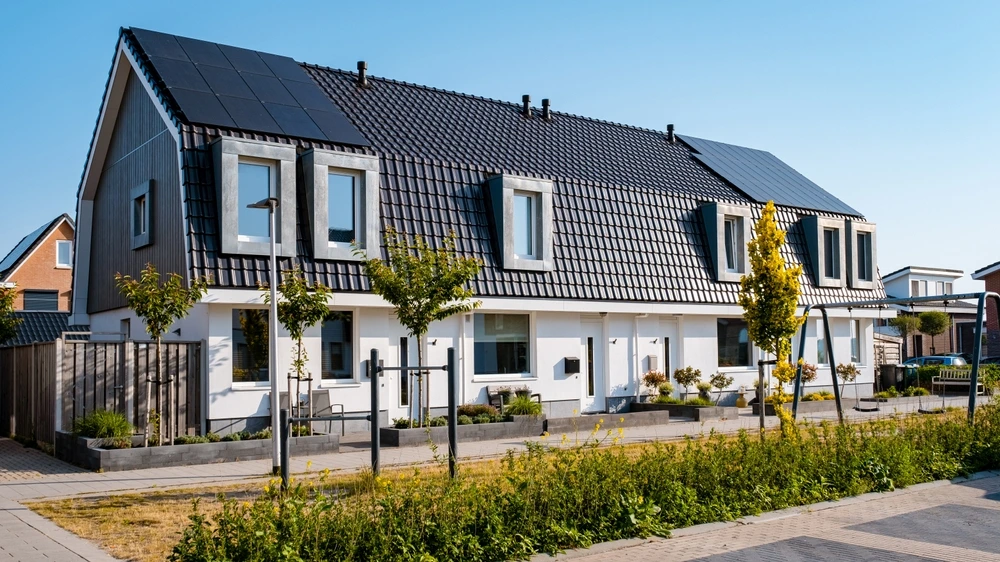 Rij huizen met bomen en zonnepanelen op het dak in een duurzame wijk