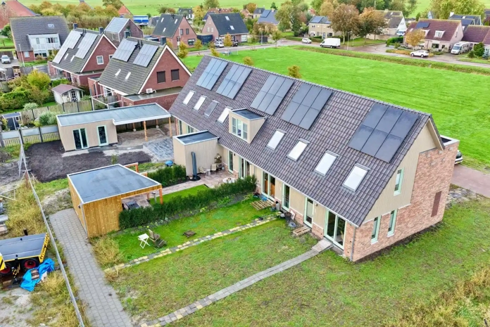 Luchtfoto van nieuwbouwwoningen met PVT-panelen op het dak in Oosthem