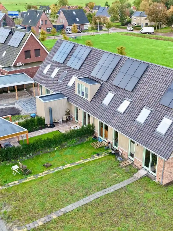 Luchtfoto van nieuwbouwwoningen met PVT-panelen op het dak in Oosthem