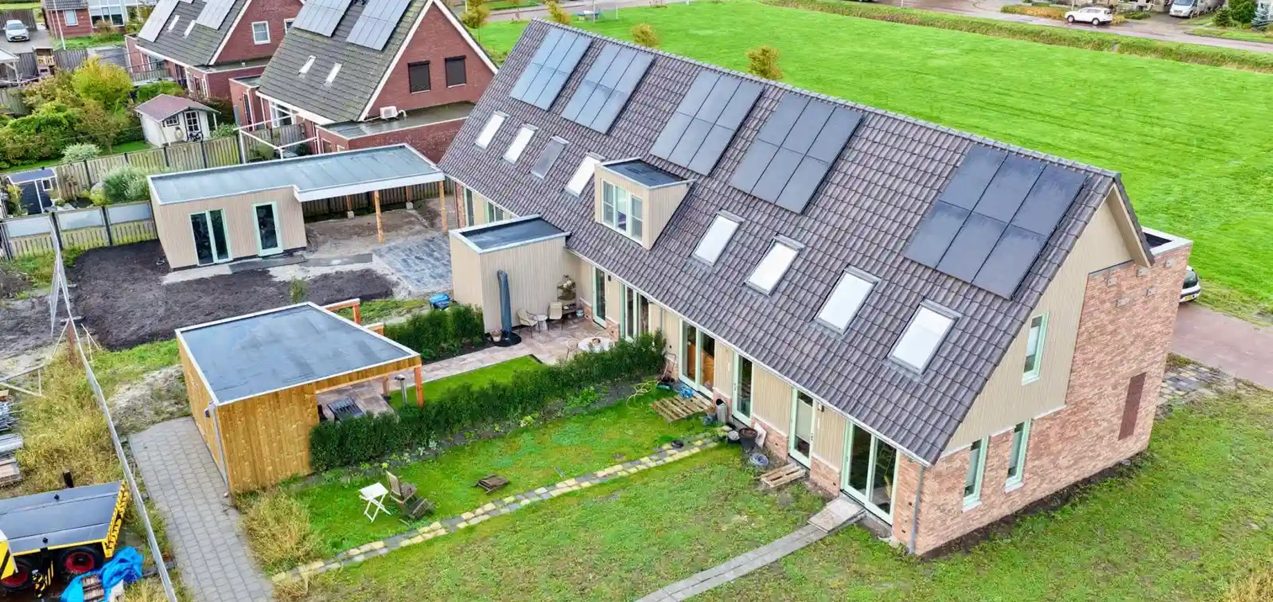 Luchtfoto van nieuwbouwwoningen met PVT-panelen op het dak in Oosthem
